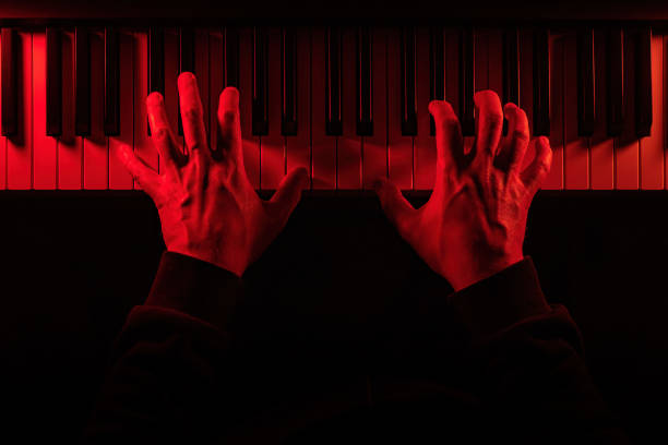 istock Eerie hands poised on piano keys, illuminated by menacing red light, evoking suspense and dread. The shadowy scene feels like a soundtrack to a horror film or game, embodying fear and unease. 2188799196