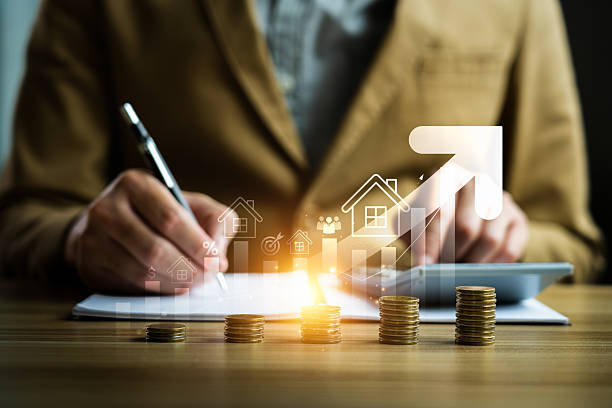 istock Businessperson Analyzing Financial Growth with Stacked Coins, Rising Graph, and Virtual Real Estate Icons, Representing Investment, Property Market Trends, and Economic Development 2188803358