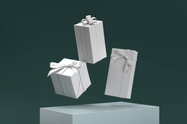 istock Three white boxes with bows on top of a green background 2188814551
