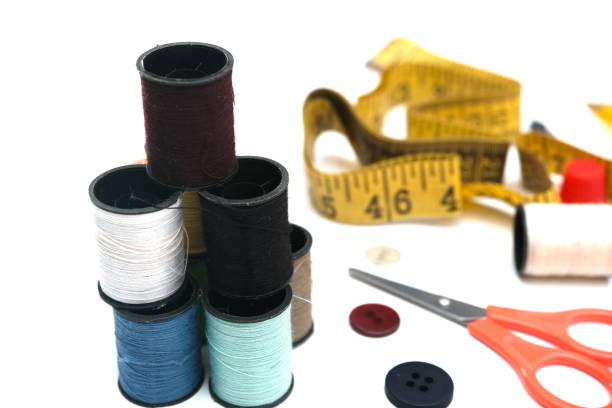 istock Flat lay of sewing tools featuring thread spools, a flexible measuring tape, scissors, buttons, and a thimble 2188815535