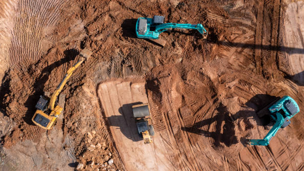 istock Aerial view road motor grader flatting dirt road surface, Motor grader road construction grader industrial machine construction site new road, Aerial view group excavator working on construction site. 2188815875