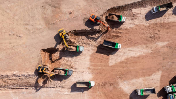 istock Aerial view road motor grader flatting dirt road surface, Motor grader road construction grader industrial machine construction site new road, Aerial view group excavator working on construction site. 2188815966