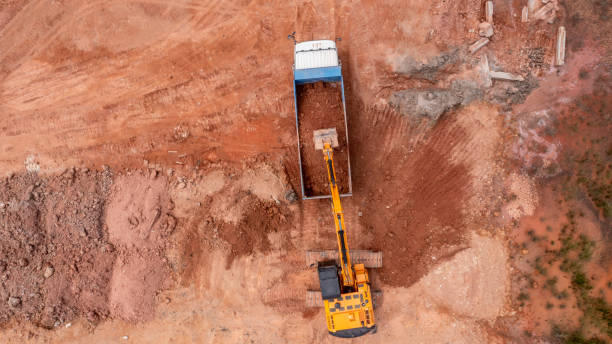 istock Aerial view road motor grader flatting dirt road surface, Motor grader road construction grader industrial machine on construction site of new road, Aerial view group of excavator working on a construction site. 2188815999