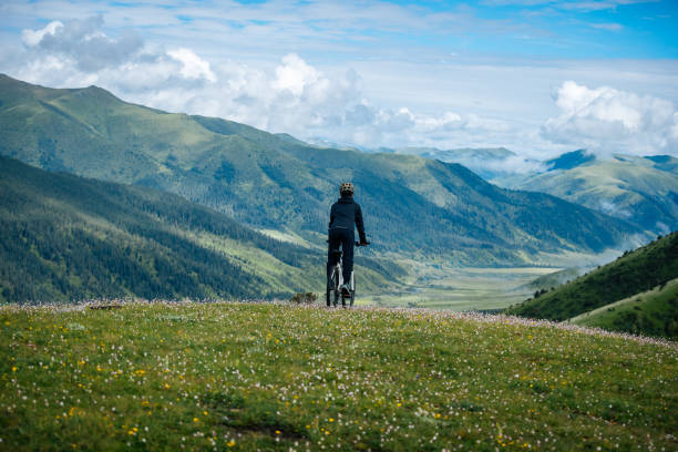 Riding mountain bike on grassland mountain top