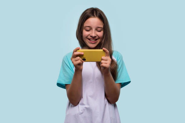 istock Girl enjoys using phone, immersed in playful moment. 2188820530