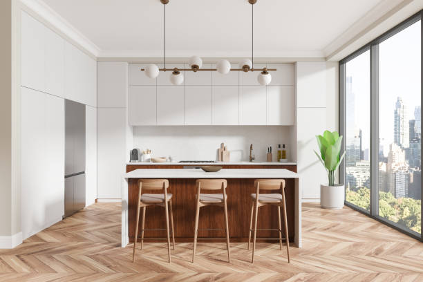 istock Modern kitchen interior with white cabinets, wood island, and large windows overlooking the city. 3D Rendering 2188823285