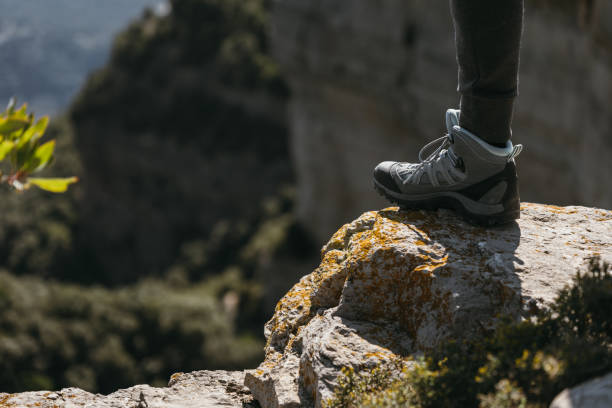 istock Hiking shoe stepping on a small rock with blurred landscape background on sunny day. Copy space. 2188824574