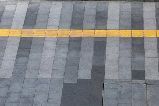 istock A gray and black sidewalk with a yellow line down the middle. 2188824605
