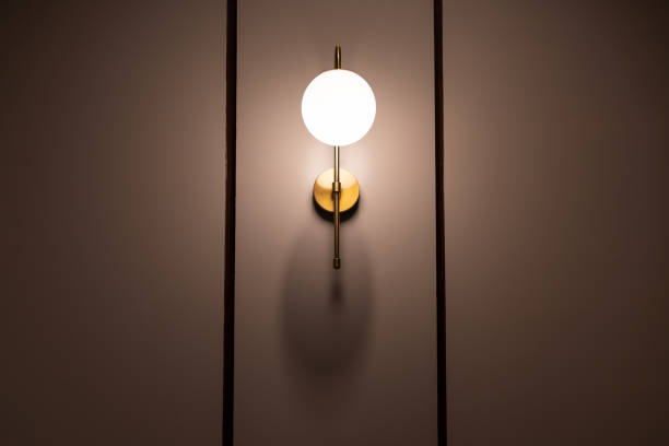 istock A gold lampshade with a white light bulb is lit up 2188824612