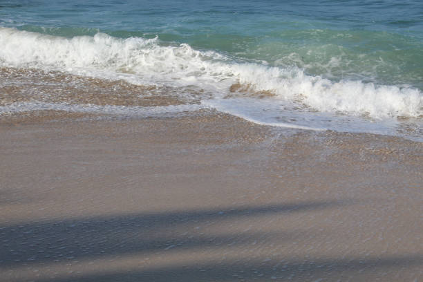 Empty beach. Clear sea water, sea waves, sea foam and white sand