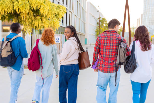 istock Group of diverse students walking together outdoors with backpacks 2188826183