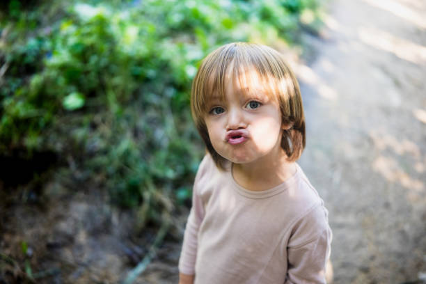 Portrait of a pouting little child in a forest trail