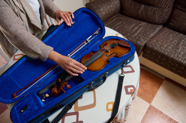 istock Person placing a violin into its blue velvet-lined case on a table 2188830044