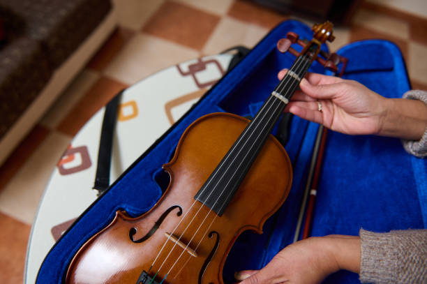 istock Person handling a violin placed in a blue velvet-lined case 2188830205