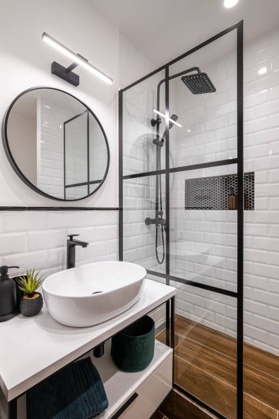 istock Simple bathroom with black shower, round mirror and classic white tiles 2188830491