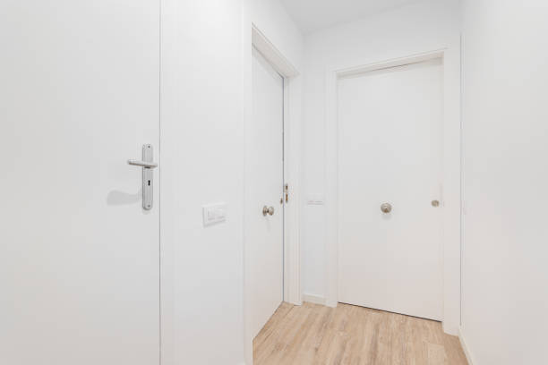 istock Empty entrance with white closed doors and wood flooring. 2188832170