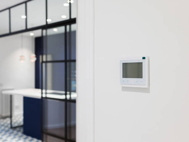istock Console for controlling heating and cooling on the white wall in modern apartment. Wall-mounted control panel in a room for air-conditioning. 2188838181