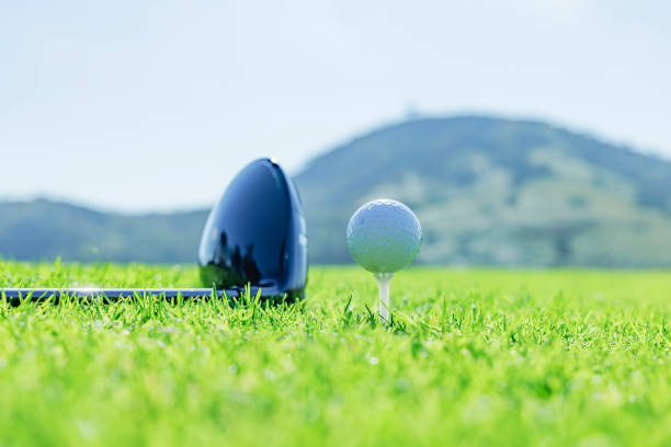 White golf ball and driver on black background. Close up.