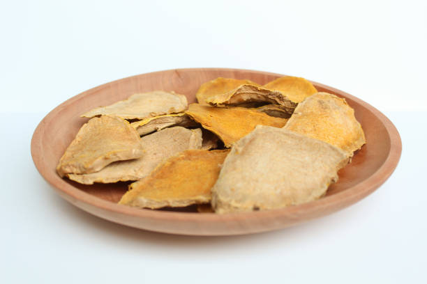 Sliced and dried rhizome of Curcuma zanthorrhiza, or temulawak, or Java ginger, or Javanese ginger, or Javanese turmeric. Isolated on white background