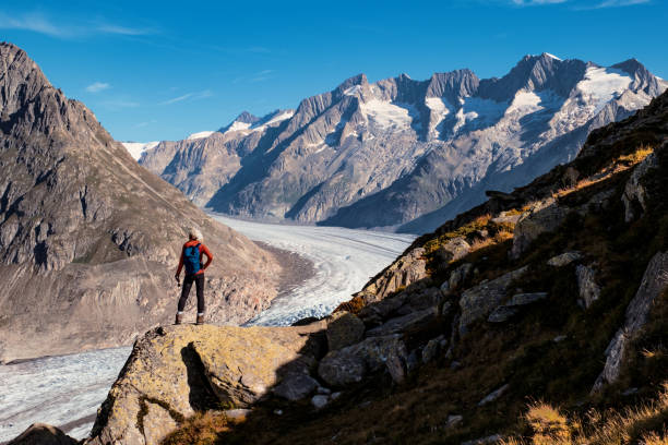 Senior woman enjoying the view from the Aletsch Glacier trail between Bettmeralp to Marjelen in the Valais district of Switzerland.