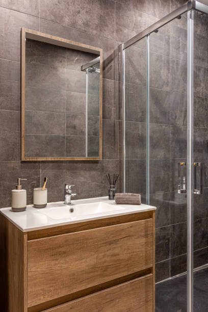 istock Modern refurbished bathroom with shower zone. Wooden base with white sink and mirror. 2188847956
