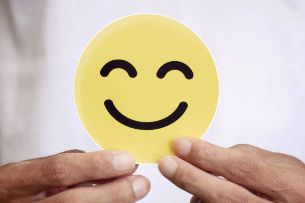 istock Hands holding a happy smiling face in yellow. Concept for positive customer satisfaction reviews, mental health, compliments, world mental health day 2188857837