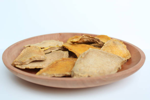 Sliced and dried rhizome of Curcuma zanthorrhiza, or temulawak, or Java ginger, or Javanese ginger, or Javanese turmeric. Isolated on white background