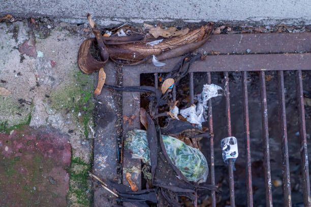 istock garbage and a banana peel lying on the grate in the sidewalk. 2188870762