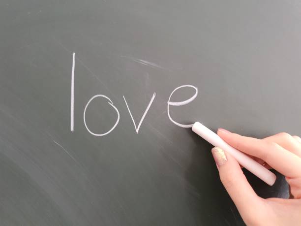 istock Student writing the words LOVE to a chalkboard at school 2188872730