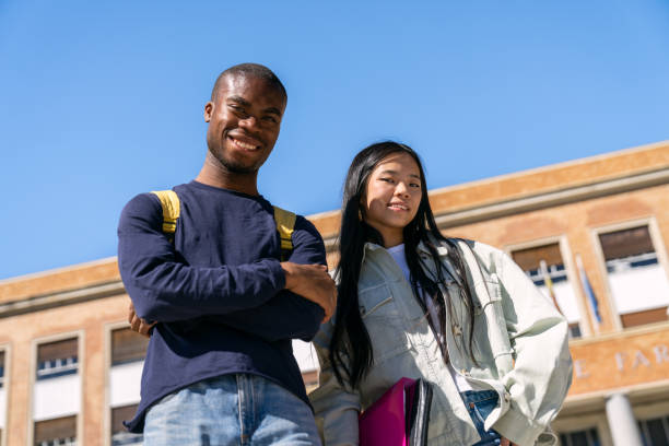 istock Two smiling multiethnic students standing in front of university building 2188874632