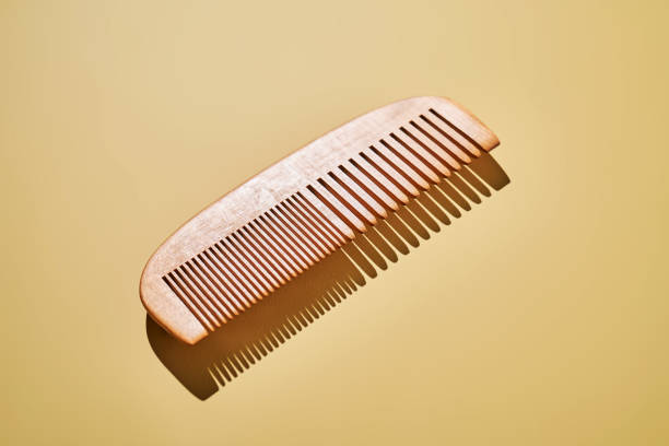 istock Wooden hair comb on a yellow background. 2188875643