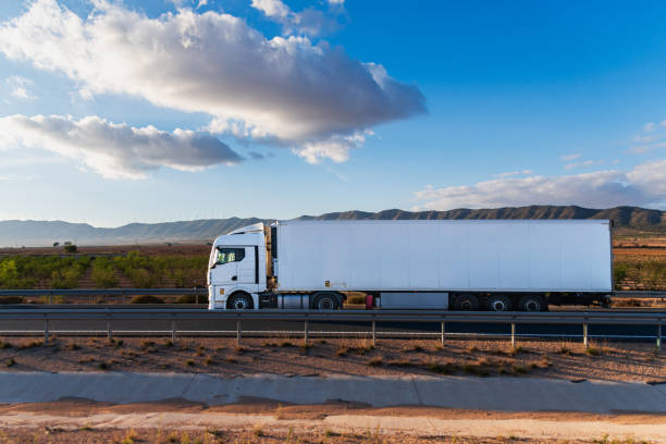 istock Refrigerated semi-trailer truck driving on a highway at dawn, side view. 2188877795