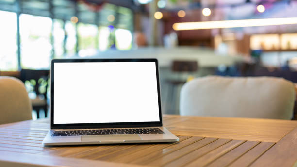 istock Laptop with blank screen and placed on a wooden table inside a coffee shop. Workspace background new project on laptop computer with blank copy space screen for your advertising text message. 2188877879