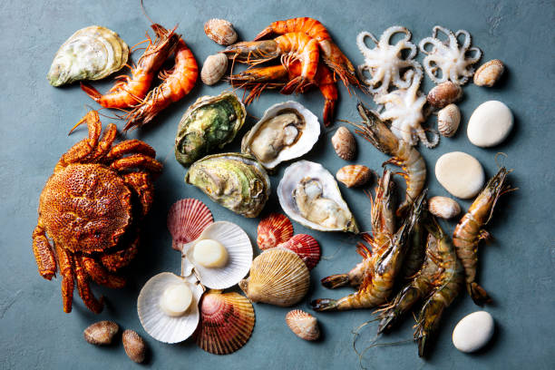 istock Fresh seafood assortment, prawns, crab, oysters, langoustines, scallops, octopuses on blue background. Top view. 2188882848