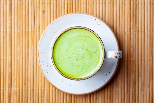istock Matcha, green tea latte in a cup. Brown bamboo background. Close up. Top view. 2188882861