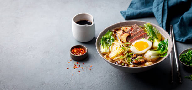 istock Asian soup ramen with beef, vegetables and egg in bowl. Grey background. Copy space. 2188883560