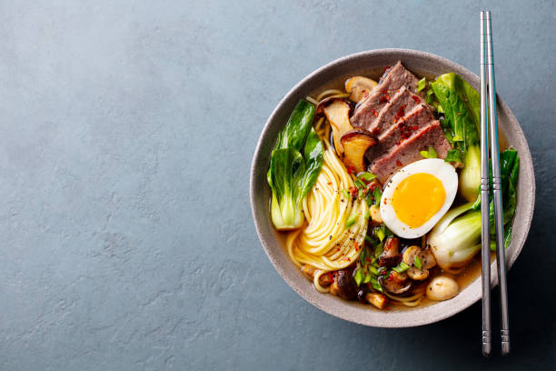 istock Asian noodle soup, ramen with beef, vegetables and egg in bowl. Grey background. Copy space. Top view. 2188883989