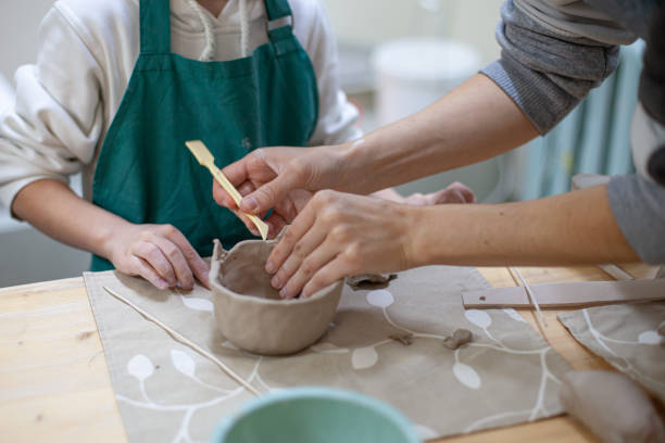 Close up of hands in clay modeling process.