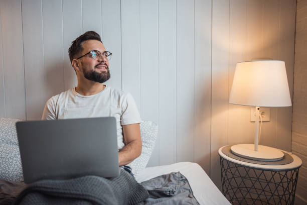 istock Man in bed with laptop in hotel room 2188902695