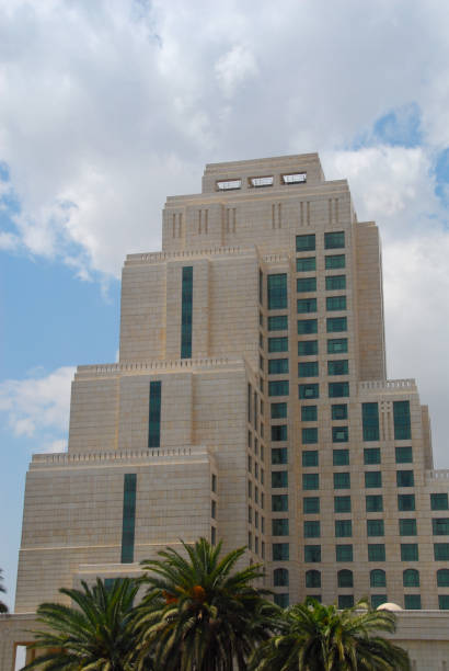 cars parked on the roof of a parking garage in downtown Tel Aviv, Israel, between an apartment building and an office building