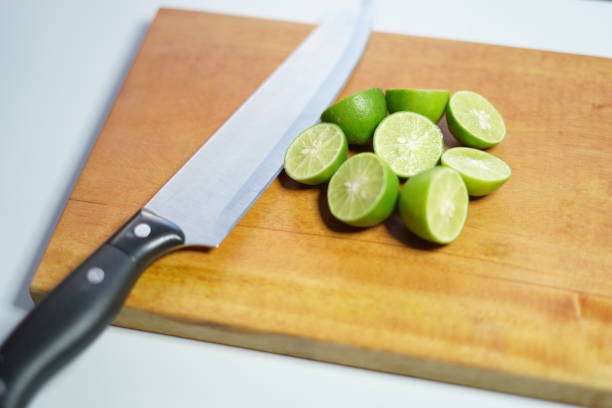 sliced limes on a chopping board with knife