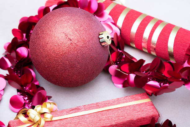 A vibrant red Christmas ball is beautifully surrounded by an array of delicate pink and shimmering gold decorations that enhance its charm