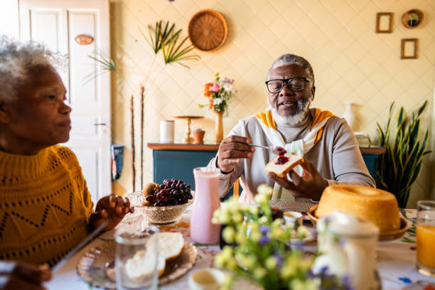 istock Mature man spreding jam on bread while habing breakfast with his wife at home 2188903902