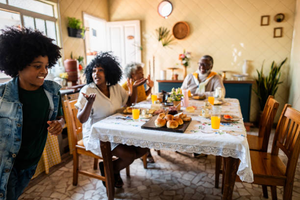 Boy running in the kitchen while his family is having breakfast