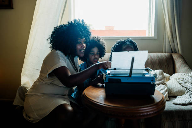 Mother and children typing on a typewriter at home