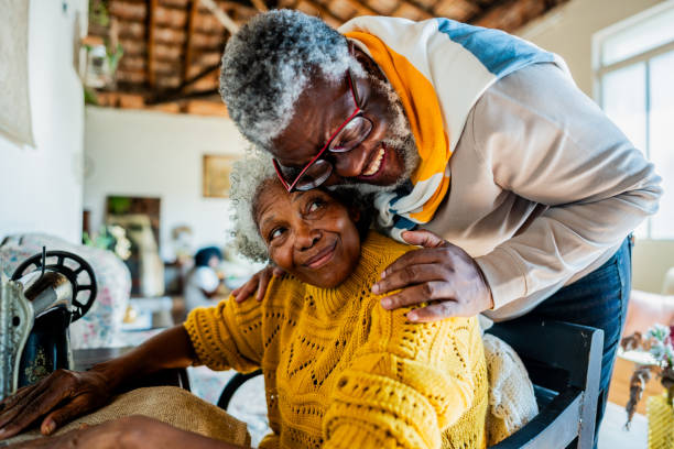 istock Husband embracing his wife while she's sewing on a sewing machine at home 2188904107