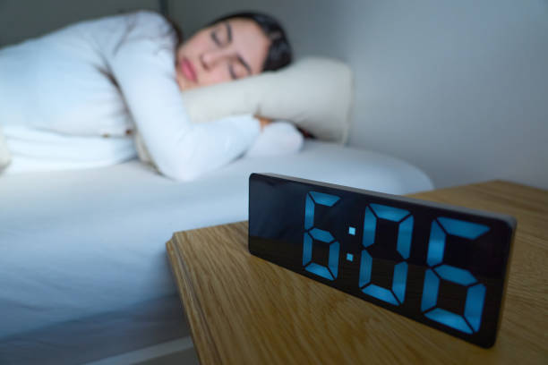 istock Woman sleeping in bed, alarm next to her 2188904493