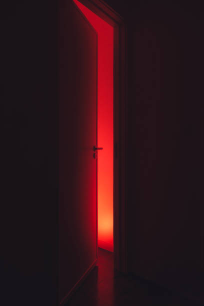 istock Horror scene behind door with red light 2188905421