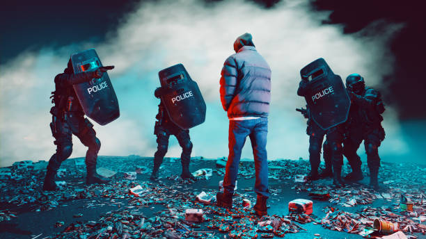 Tense standoff between a lone figure in a hooded jacket and a group of heavily armed police officers equipped with riot shields and tactical gear. They stand in a debris-strewn area, with smoke or fog creating a dramatic and suspenseful backdrop. The red and blue lighting adds an intense, cinematic feel, highlighting the contrast between the solitary figure and the law enforcement team.