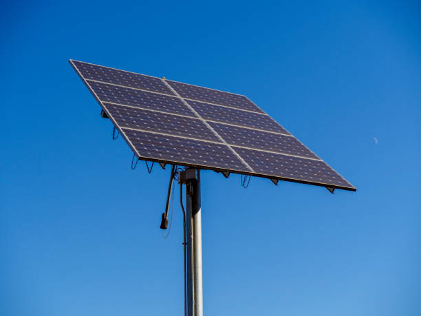istock The image shows a solar panel mounted on a tall pole against a bright blue sky. 2188907069